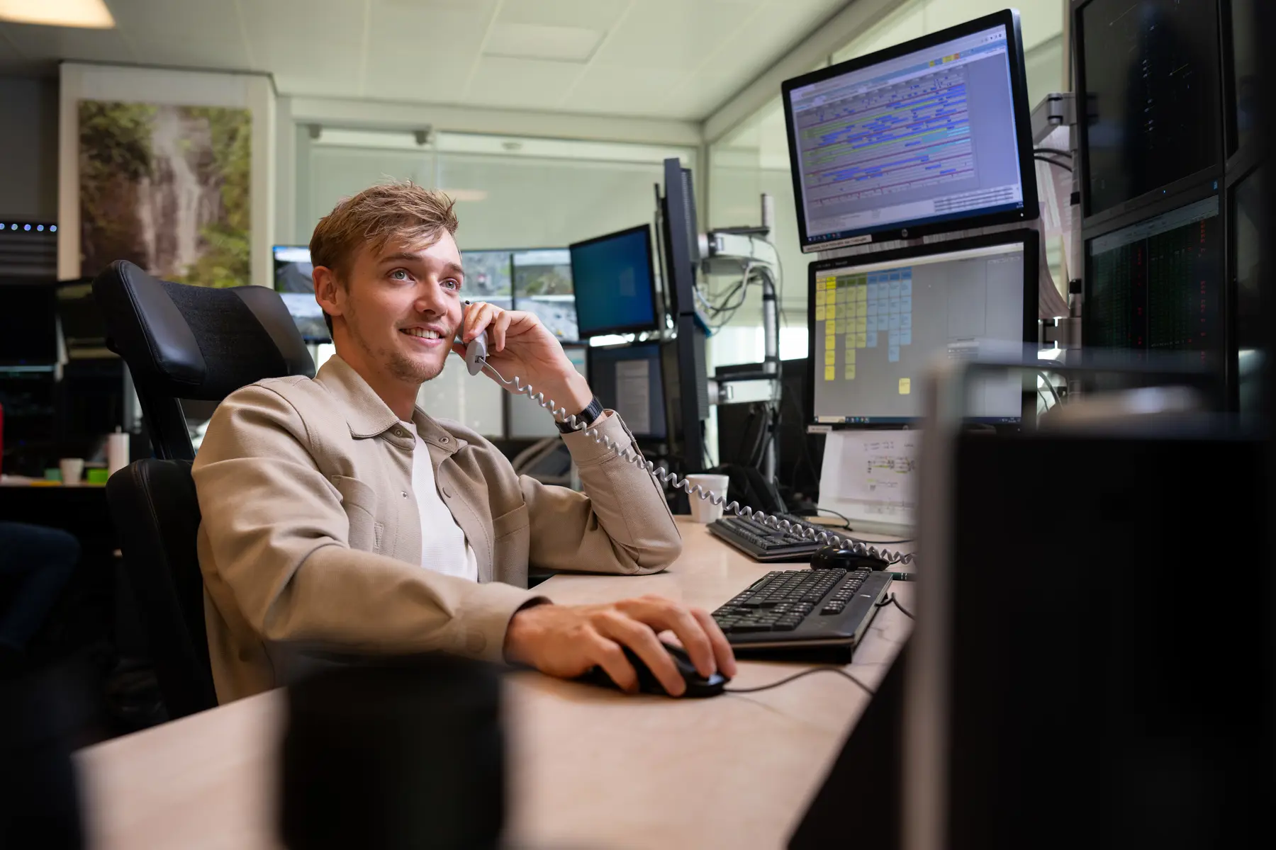 Thomas zit achter zijn bureau te bellen