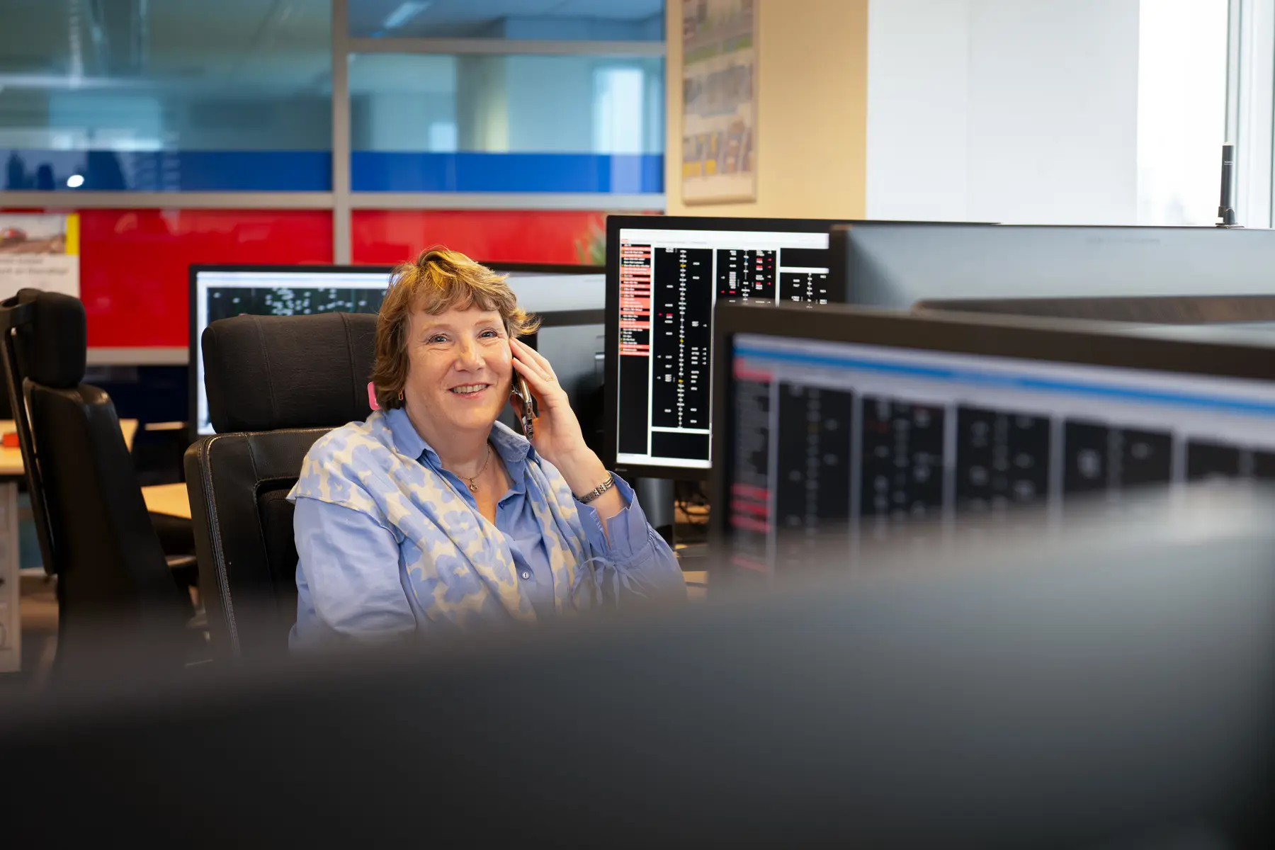 Jacqueline zit achter haar bureau te bellen