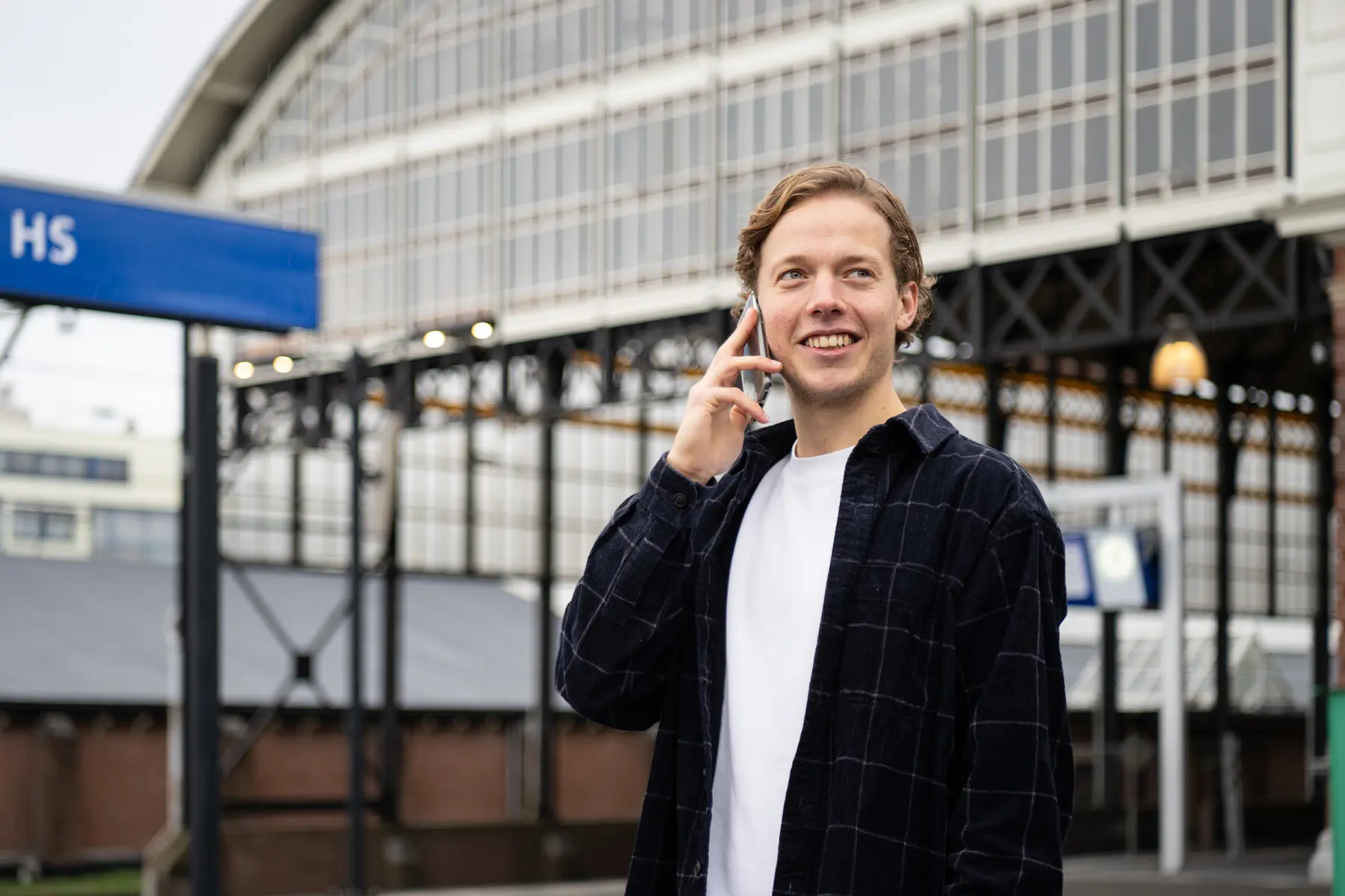 Roel is aan de aan de telefoon op station denhaag HS