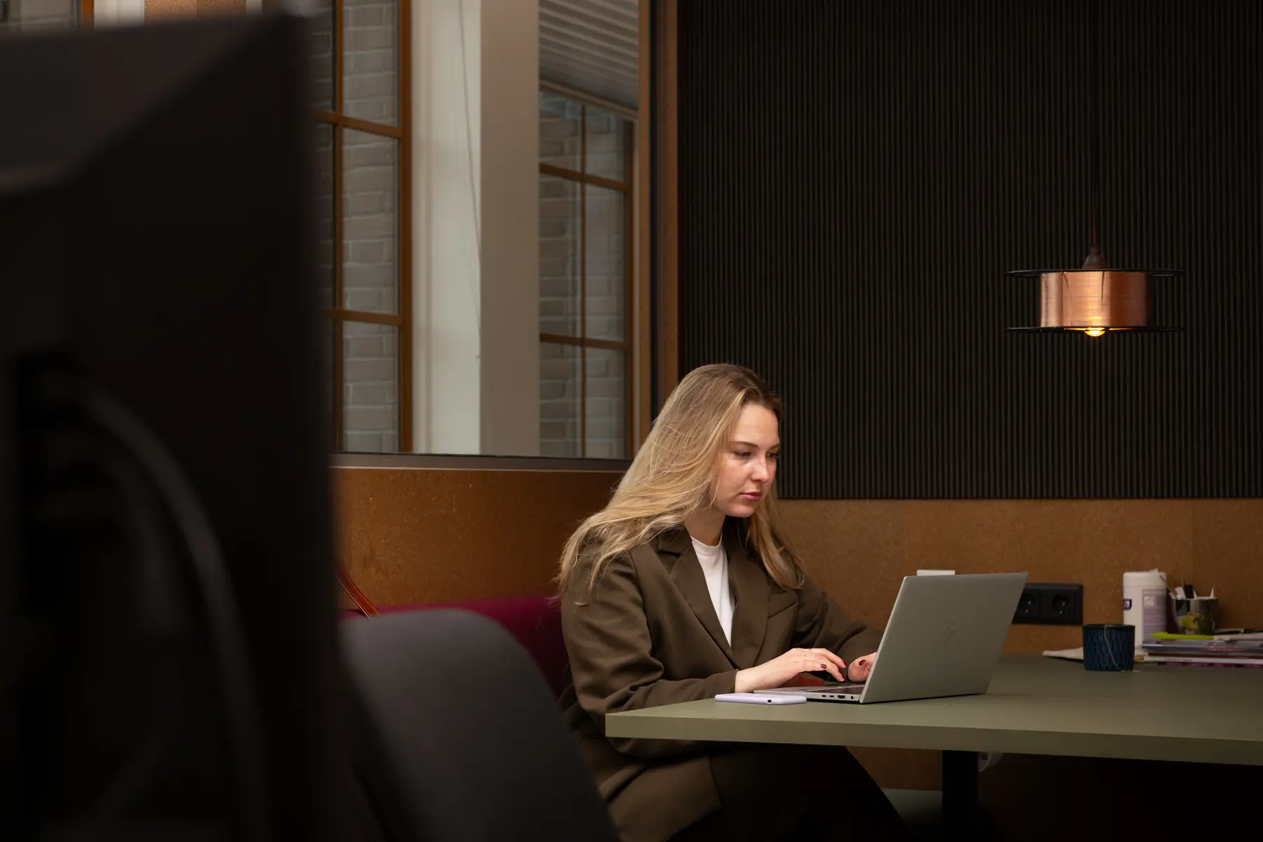 Simone zoekt iets op de laptop met een collega