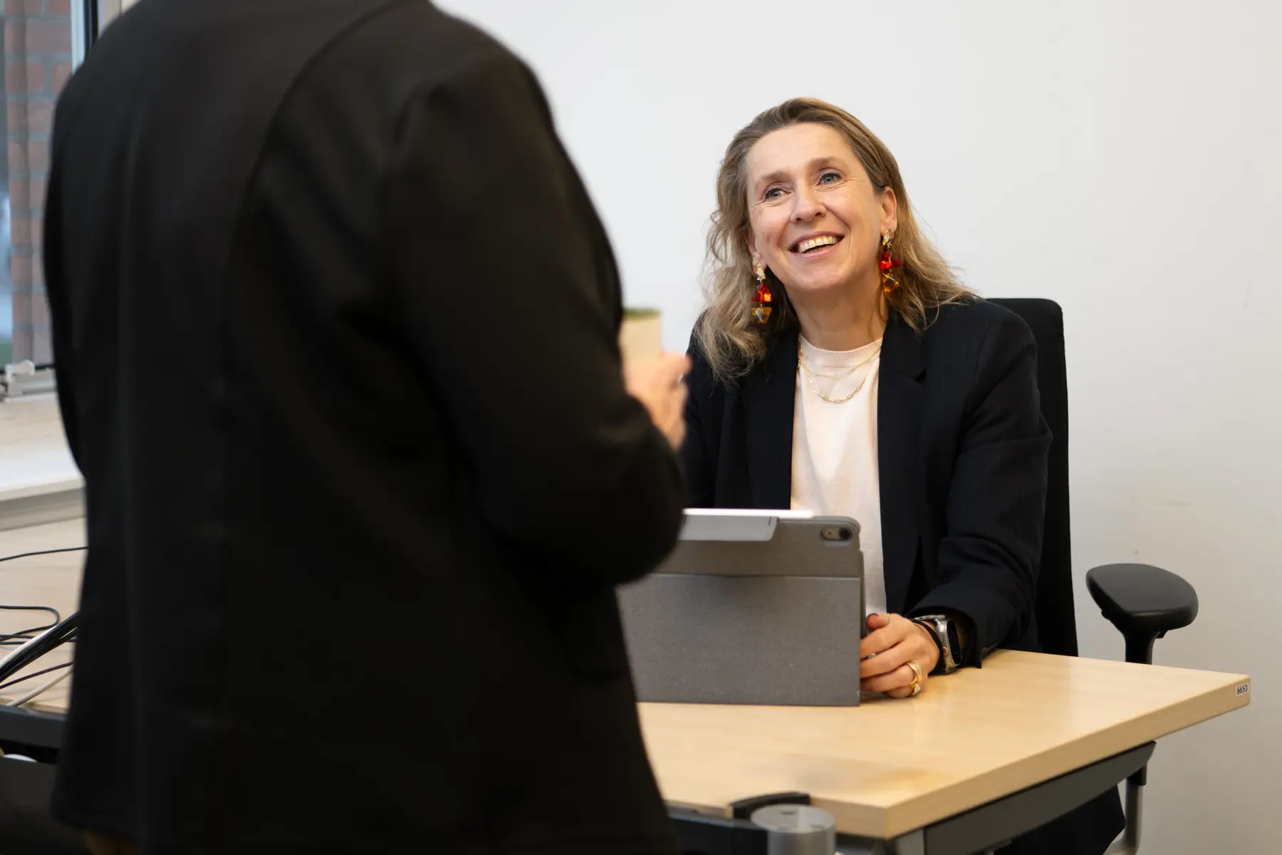 Caroline zit aan haar bureau en is in gesprek