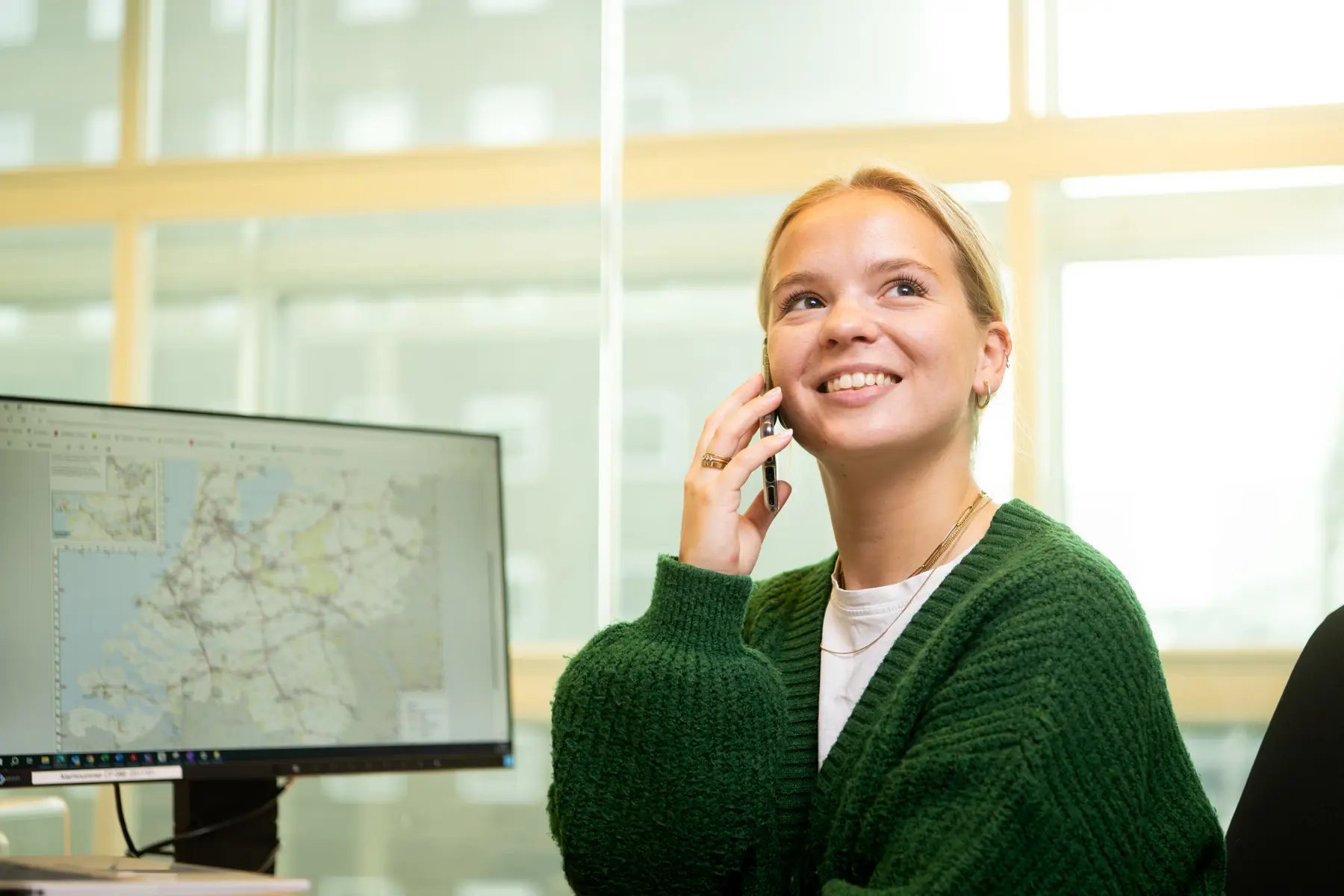 Anne belt achter haar bureau